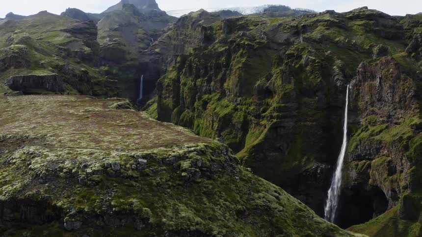The waterfalls pour off the mountains