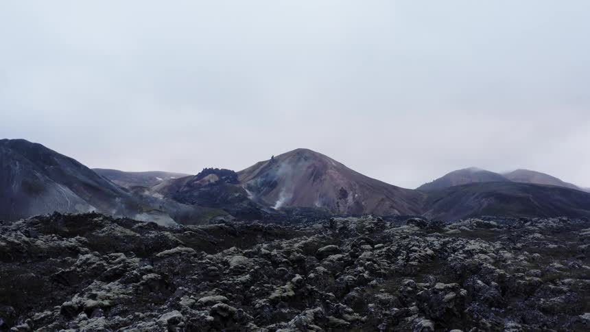 View of volcanic field with distant mountains