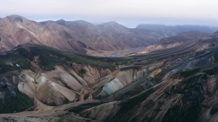 Panoramic view of rolling green hills over the desert mountains