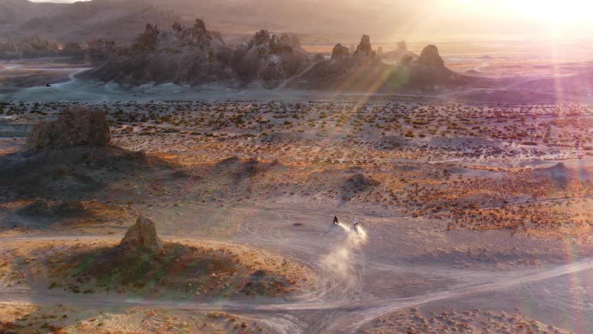 Cyclists leave a trail of dust behind them as they ride in circles in the desert