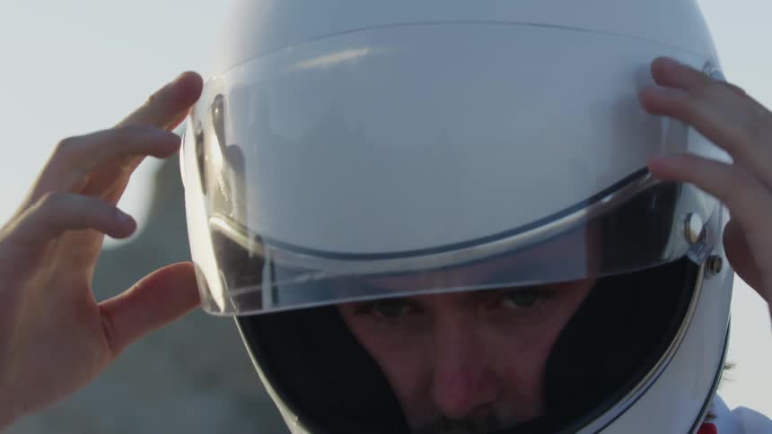 A man lowers the visor on his crash helmet
