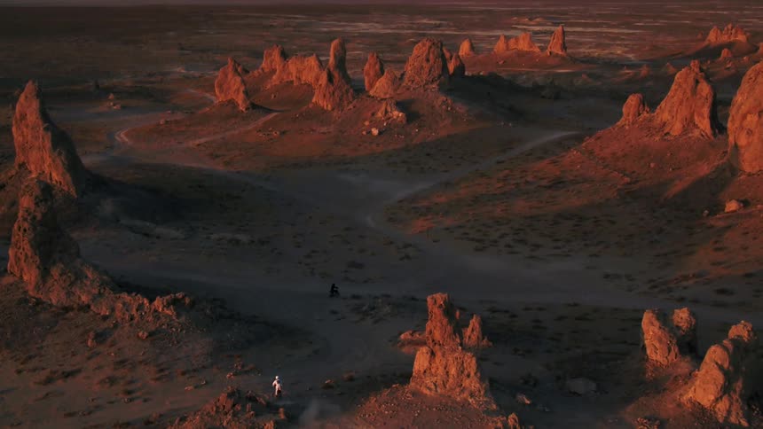 Bicyclists ride around rock formations in a canyon