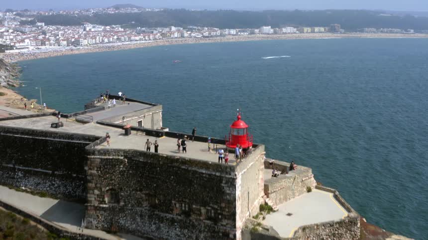 People are touring a light house on the shore