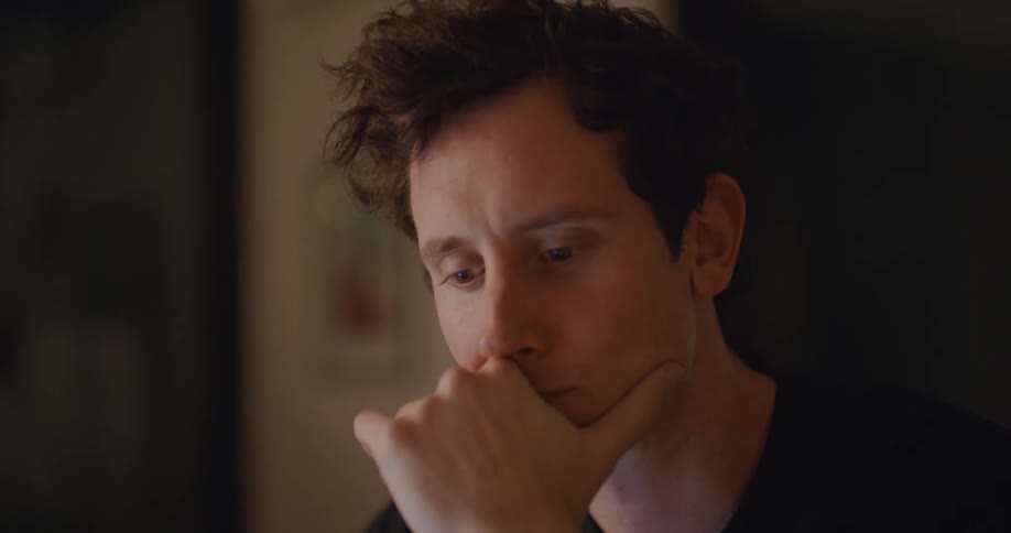 A man stops to think before typing on his laptop
