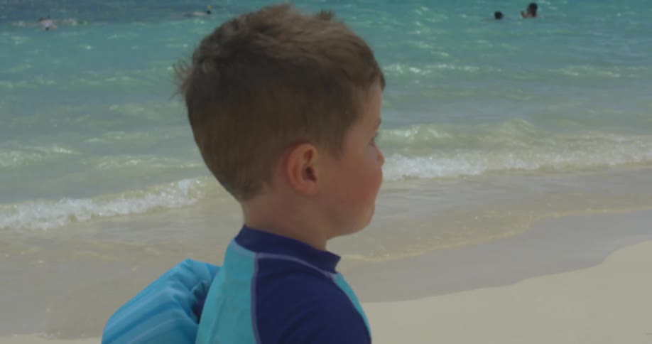 A boy runs along the shore