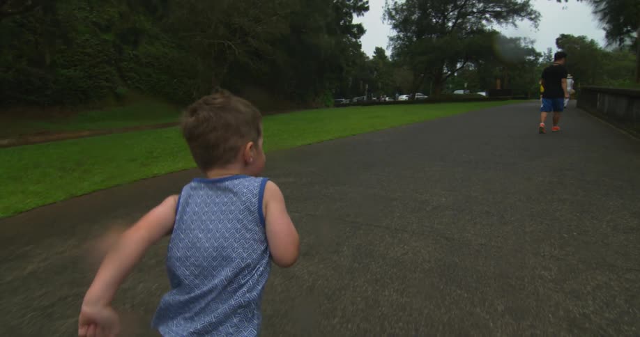 A boy is running forward towards other people