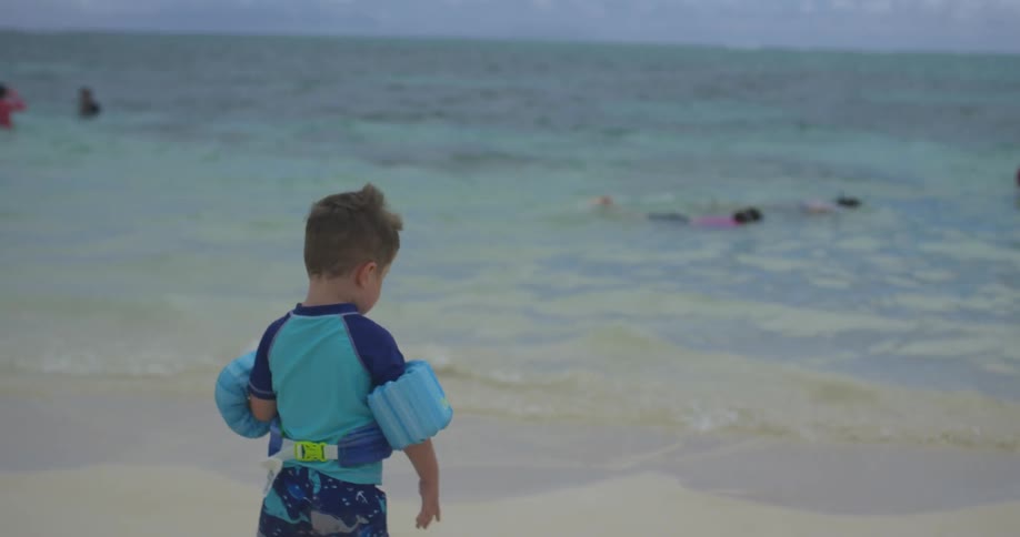 A boy runs over to the water