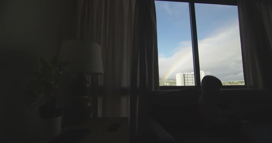 A dark room has a window overseeing a city