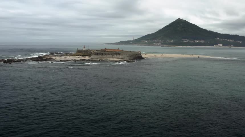 An old fort surrounded by a wall is on a remote island