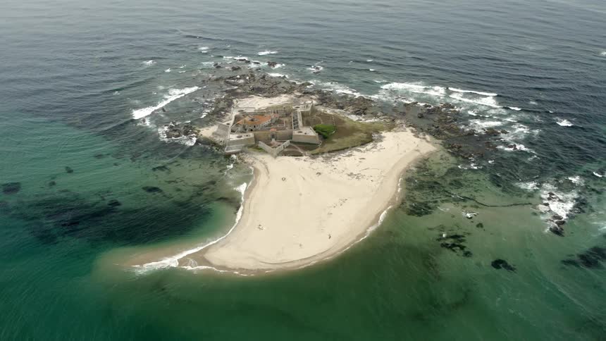 An island in the ocean with a building on it