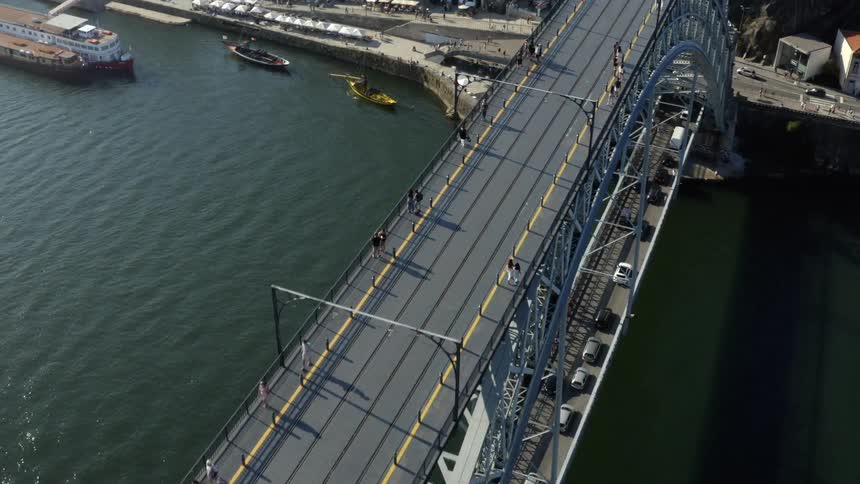 People walk on the upper deck of the dom luis i bridge across the douro river