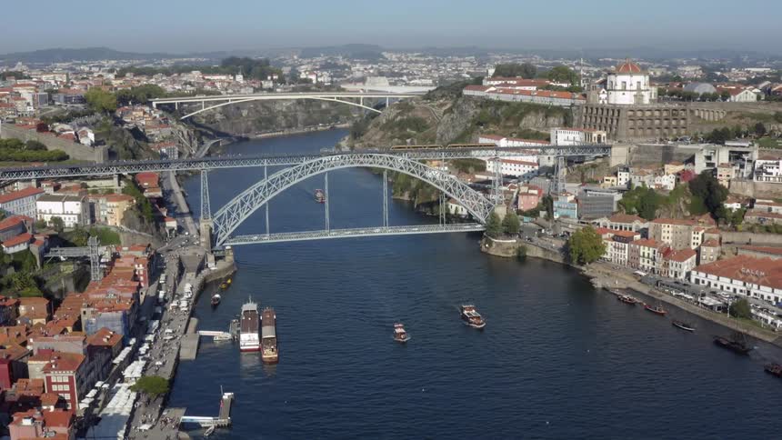 A bridge spanning a river in a city during the day