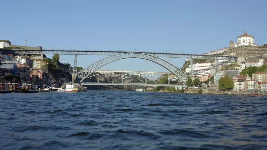 A boat makes its way down a river that runs through an urban area