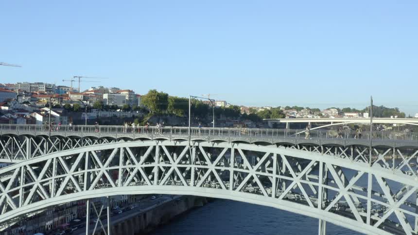 A bridge spanning a waterway in a metropolis during the day