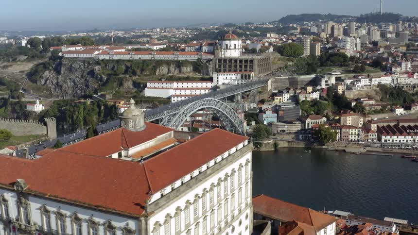 A bridge over a river from one side of town to the other with many buildings on the other side