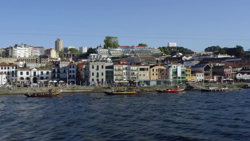 Drone footage of a coastal town with larger buildings and skyscrapers in the distance