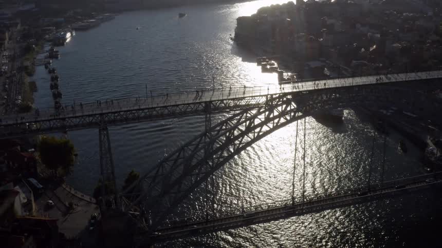 Aerial view of people going over arch bridge as the sun shining bright