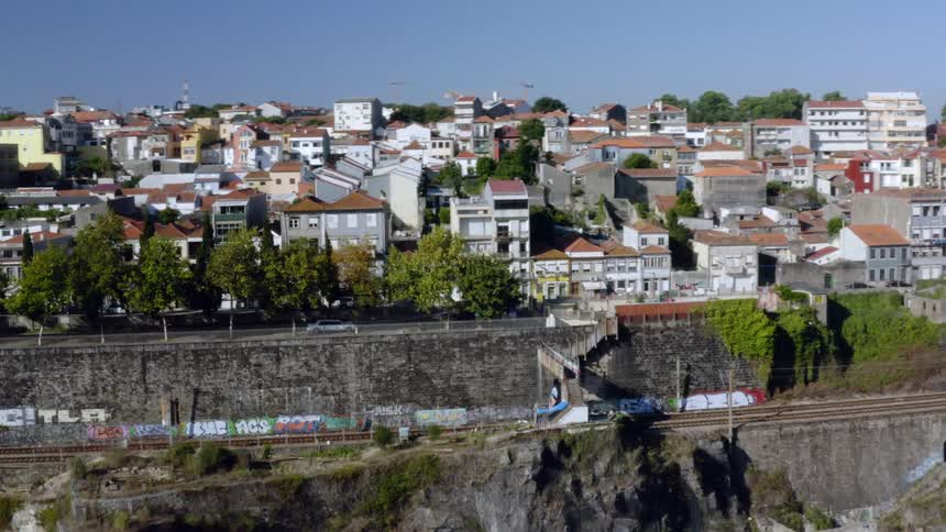 A dense city neighborhood sits on top of a cliff