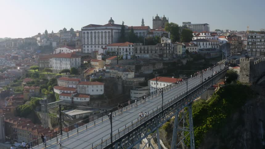 A train is traveling over a bridge to a big neighborhood