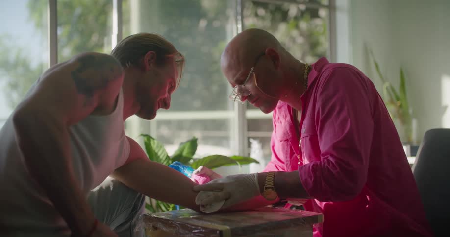 A man giving a tattoo to another person
