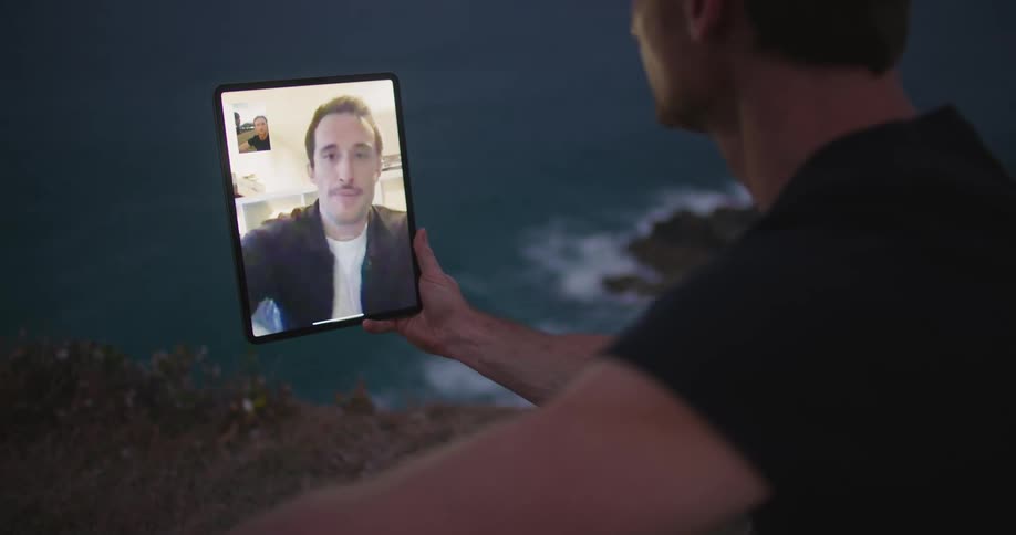 A man is having a video conference with another man on a tablet
