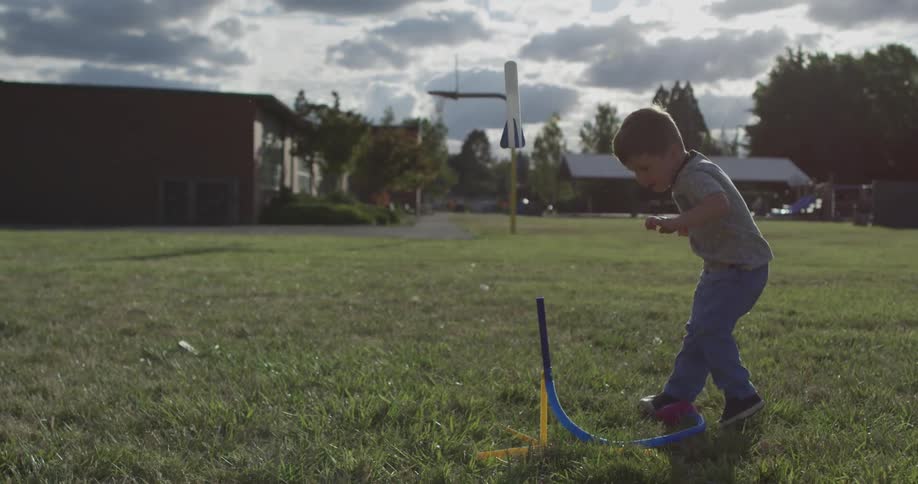 A young boy launches a toy rocket into the sky