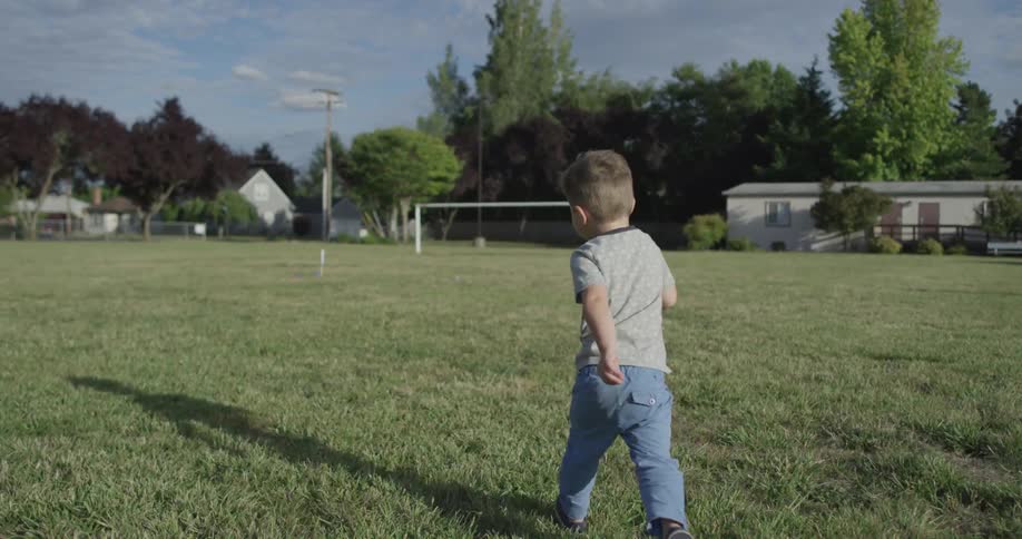 A boy runs across a soccer field