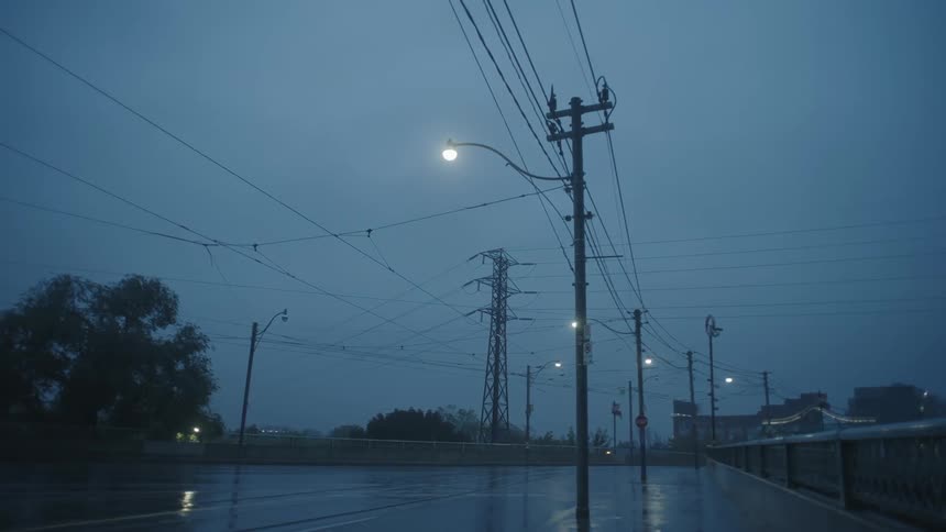 The power lines run over the empty road