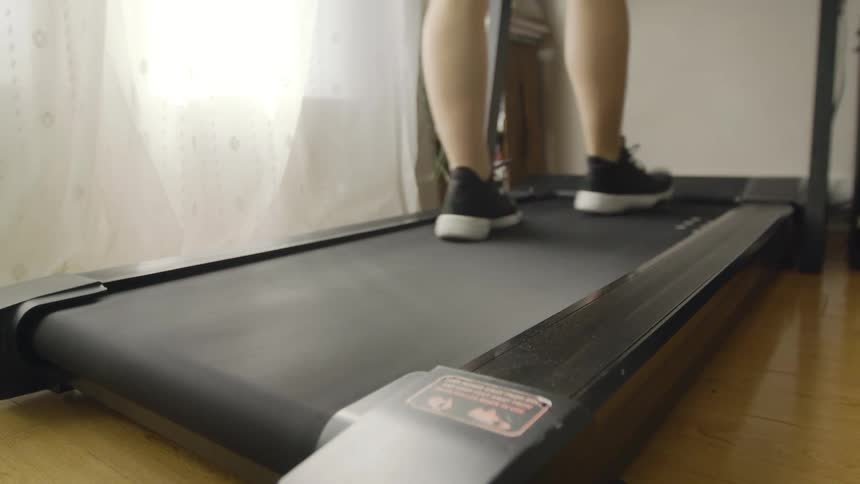 A person walks on a treadmill indoors during the day