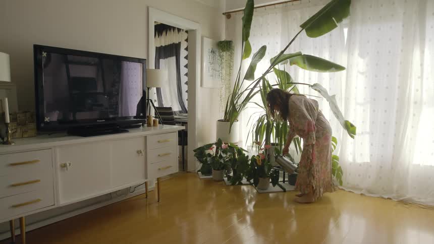 A woman waters the planets in her home