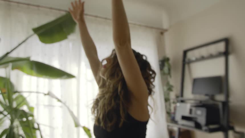 A pregnant woman stretches at home