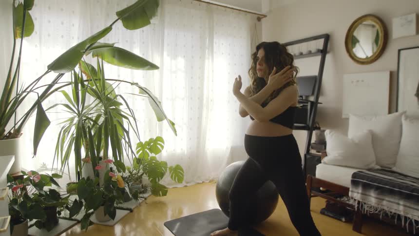 A woman is exercising in the living room