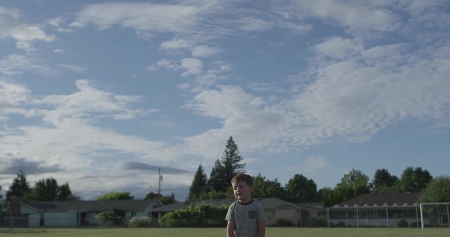 A boy look up in the sky as a toy rocket falls
