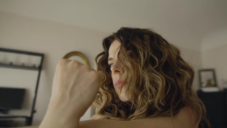 A woman at home stretches her arms and neck