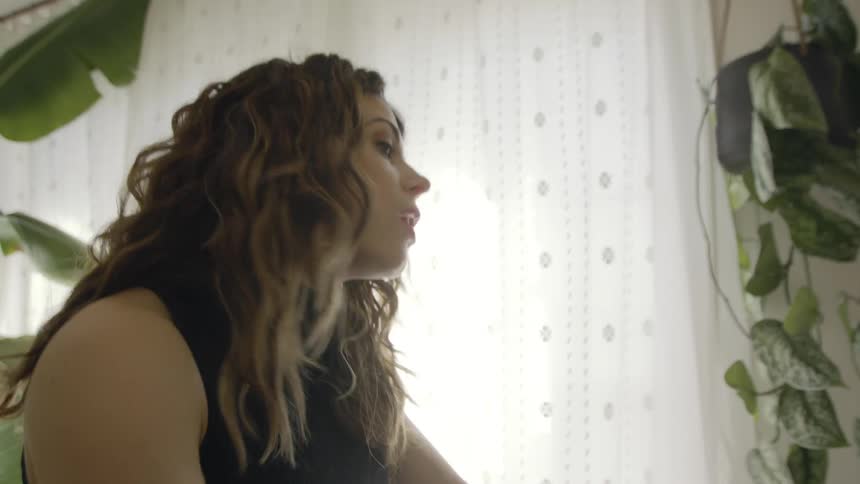 A woman sings and dances while walking in place at home
