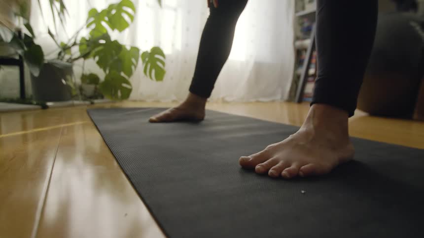 A woman is doing stretching exercises and touching the floor with her hands