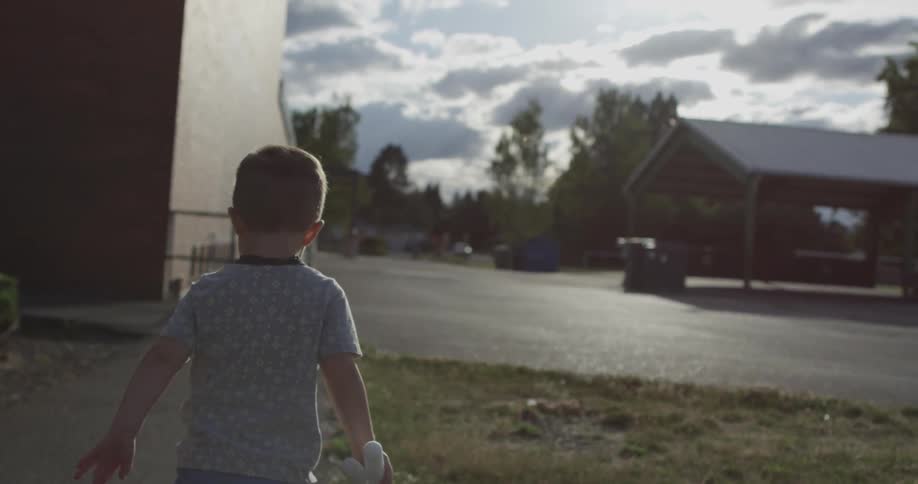 A boy runs with toy rockets in his hands