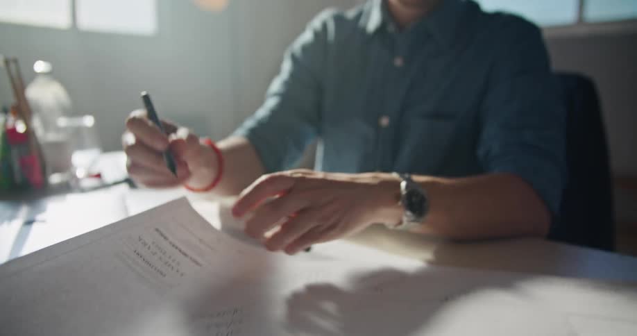 Man writes on paper while sitting at desk before considering results
