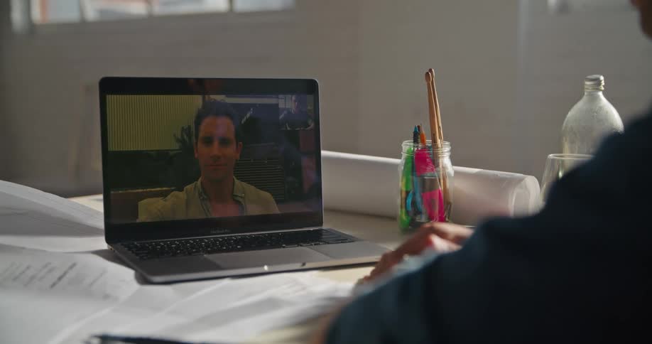 Someone is using a laptop computer to have a video conference with a man