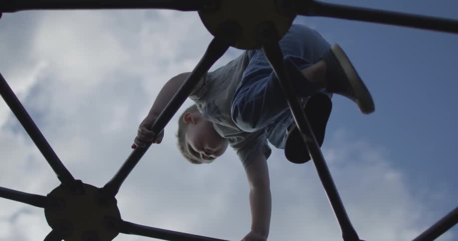A boy is climbing a jungle gym