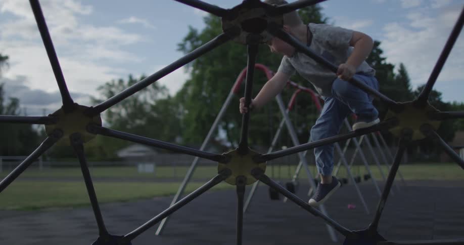 A boy is climbing a jungle gym