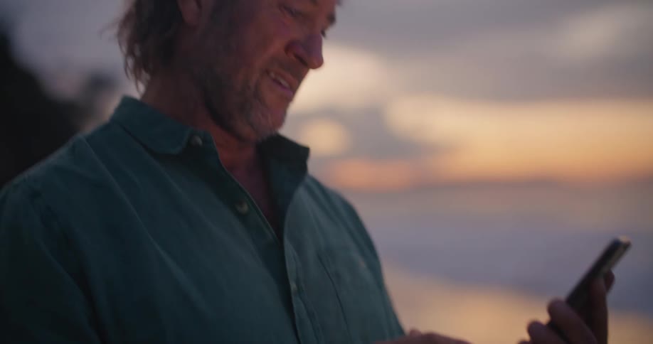 A man is holding a cell phone and making a call