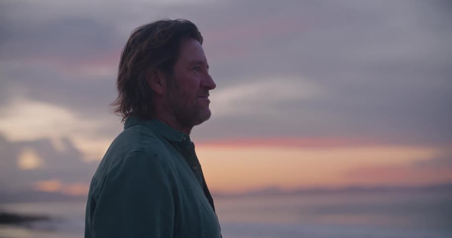 A man standing outdoors at sunset