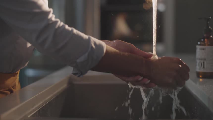 A woman is washing her hands