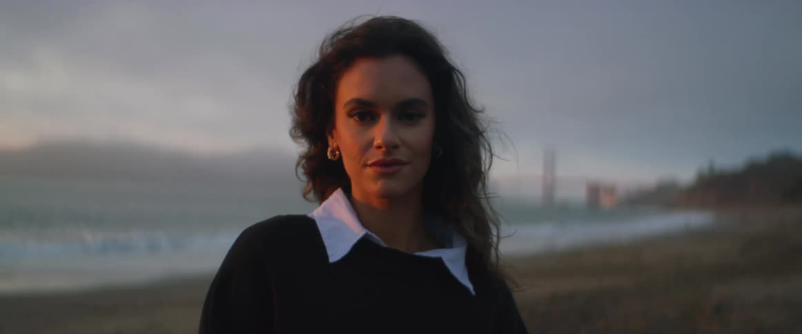 A woman on a beach with the ocean sky and clouds in the background