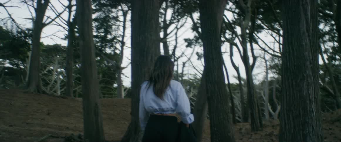 Young woman wearing a skirt wlking on a forest at evening