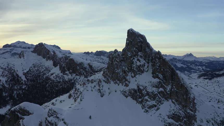 Tall mountain peaks towering up out of the snow in the wilderness at dusk
