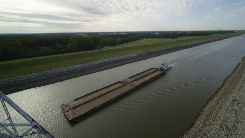 Aerial view of pusher boat pushing barges along a canal