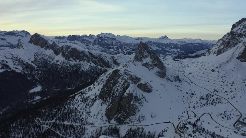 The mountain range is covered with snow and a couple of trails