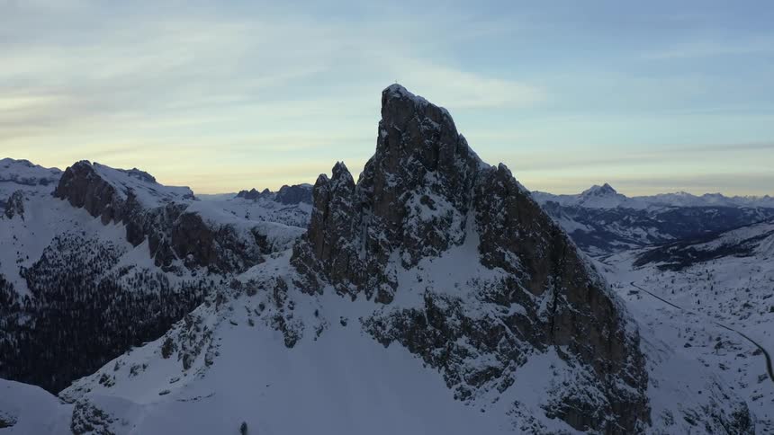 The rocky peak of a snow covered mountain during the day